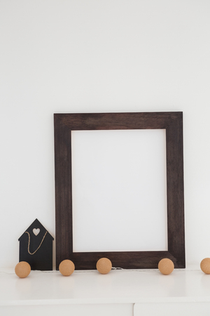 Picture frame with decorations on table against white wallの写真素材