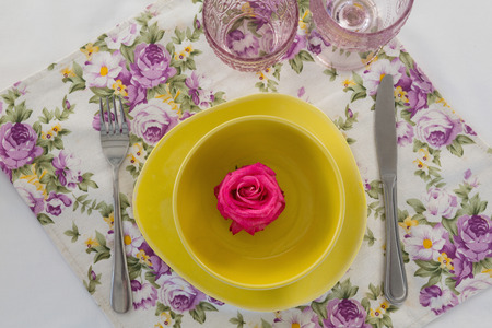 Overhead view of rose flower in a bowl with cutleryの写真素材