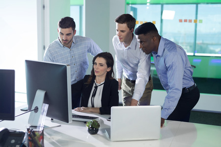 Executives discussing over personal computer in office