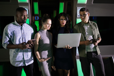 Business executives using laptop and digital tablet futuristic office