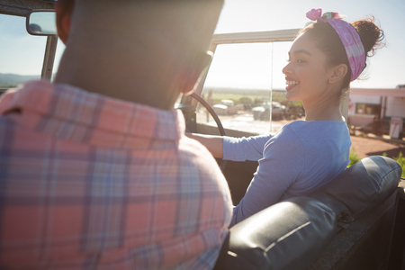 Couple interacting with each other in car at countrysideの写真素材