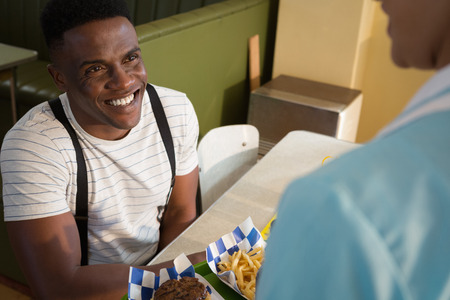 Waitress serving breakfast to customer in restaurantの写真素材
