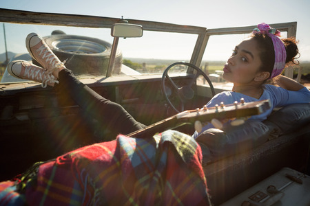 Young woman sitting in car on a sunny day