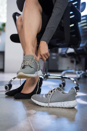 Low section of female executive wearing canvas in officeの写真素材