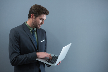 Young businessman using laptop in officeの写真素材