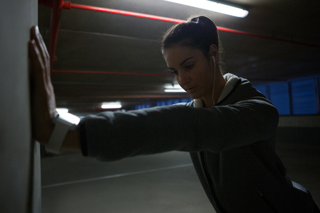 Fit woman doing stretching exercise in underground parking areaの写真素材
