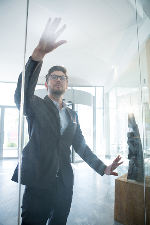 Businessman touching invisible digital screen in officeの写真素材
