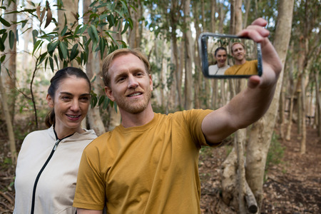 Smiling hiker couple taking selfie in the forestの写真素材