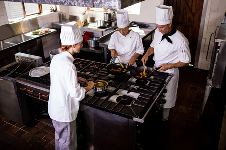 Group of chefs preparing food in kitchen at hotelの写真素材