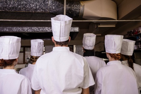 Group of chefs standing together in kitchen at hotelの写真素材