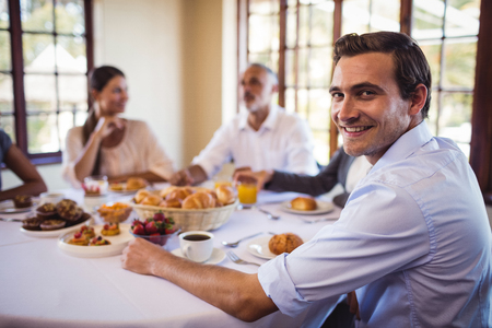 Smiling businessman looking at camera in restaurantの写真素材