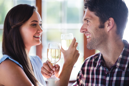 Close-up of couple having white wine in restaurantの写真素材