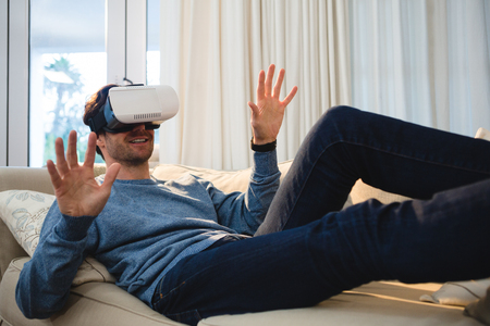 Man using virtual reality headset in living room at homeの写真素材