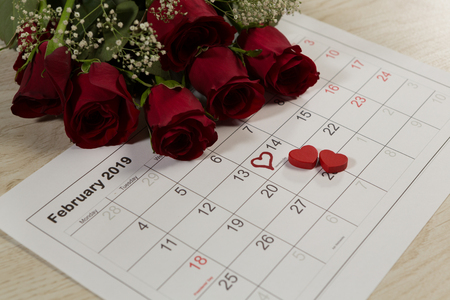 Close-up of rose bouquet with heart shape decorations on February calendarの写真素材