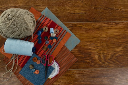 Overhead of textile, thread rolls and various equipments on a table