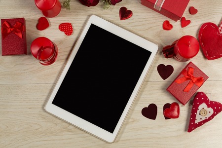 Heart shape decorations, gifts and digital tablet on wooden tableの写真素材