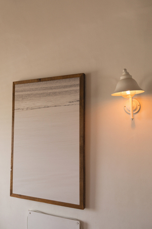 Modern wall frame near wall lamp at homeの写真素材