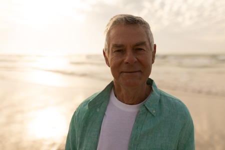 Portrait of active senior man standing on the beachの写真素材