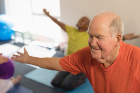 Front view of senior man exercising in fitness studioの写真素材