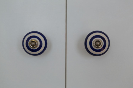 Front close-up view of a closed white modern door of cabinet at home