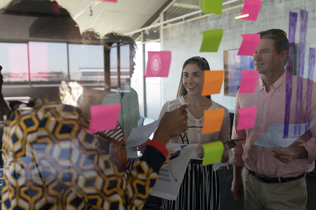 Front view of multi-ethnic business colleagues interacting with each other in modern office