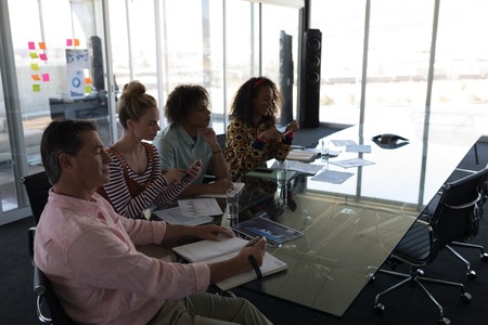 Side view of multi-ethnic business colleagues looking concentrated while in a meeting at modern...