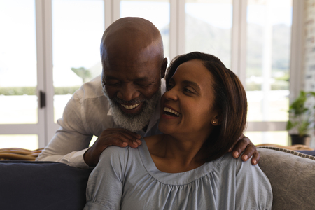 Front view of active senior couple having fun in living room at homeの写真素材