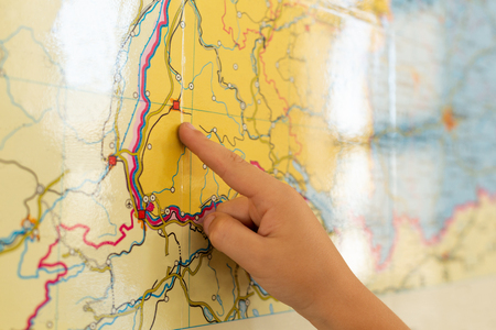 Close-up of Caucasian boy pointing his finger on world map in a classroom at elementary schoolの写真素材