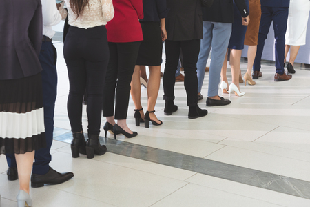 Low section of diverse business people checking in at conference registration table in office lobbyの写真素材
