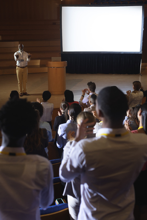 High view of matured African-American businessman standing and giving presentation in auditoriumの写真素材