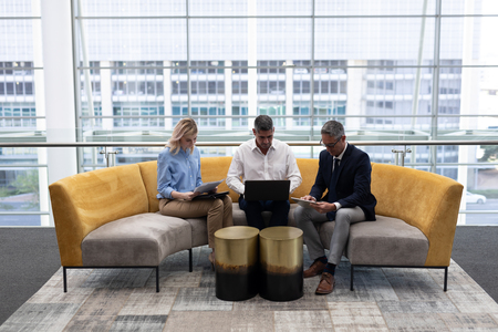 Front view of Caucasians business executives working sitting on the sofa in modern officeの写真素材