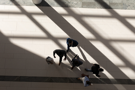 High angle view of multi-ethnic business executives walking in lobby at office