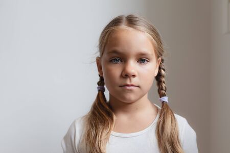 Portrait of cute Caucasian girl looking at camera in a comfortable home