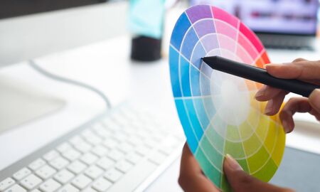 Close-up of Asian female graphic designer working with color swatch at desk in a modern officeの写真素材