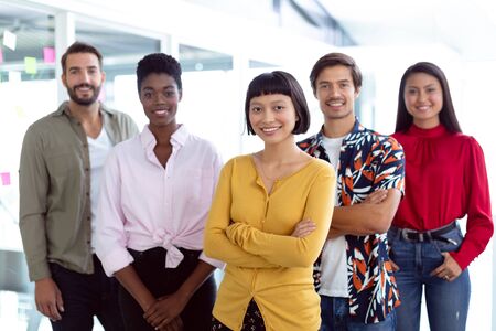 Front view of young diverse business people looking at camera in a modern office