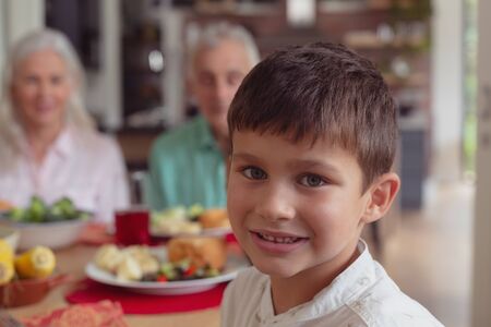 Portrait of Caucasian boy sitting at dining table at home