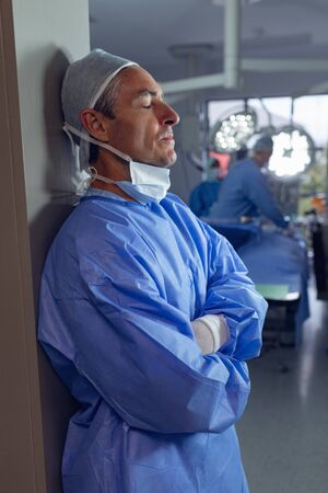 Side view of upset Caucasian male surgeon standing in operation room at hospital