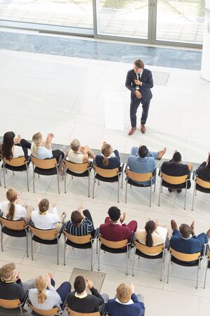 Overhead view of diverse executives sat in conference room, looking speechの写真素材