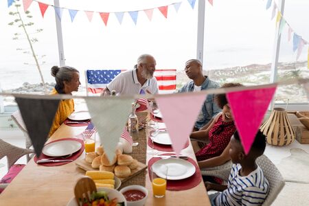 High angle view of happy mixed-race multi-generation family sitting together for having meal on a dining table at homeの写真素材