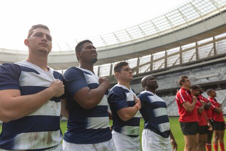 Front view of proud diverse male rugby team taking pledge together in stadium