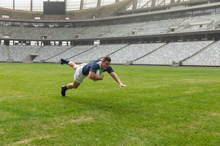 Side view of young Caucasian male rugby player playing rugby in stadium