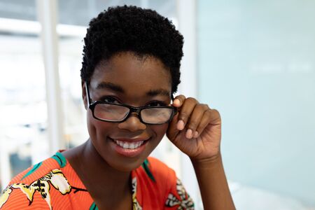Portrait of young African american female graphic designer smiling in office. This is a casual creative start-up business office for a diverse teamの写真素材