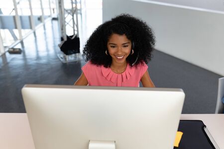 High view of African american female executive working on computer at desk in office. This is a...