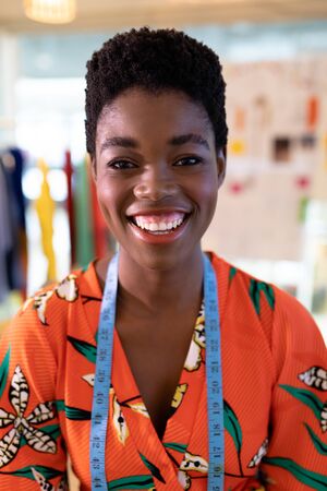 Portrait of young African american female fashion designer smiling in design studio. This is a...