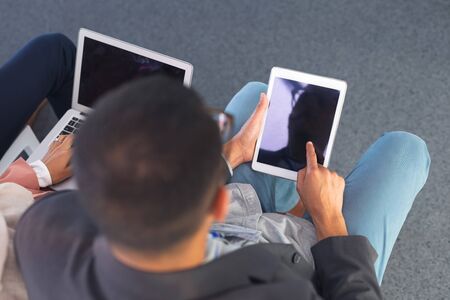 High angle view of businessman working on digital tablet in business seminar. International diverse corporate business partnership conceptの写真素材