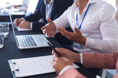Mid section of caucasian business people talking with each other in business conference. International diverse corporate business partnership conceptの写真素材