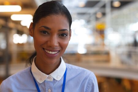 Portrait close-up of happy mixed race businesswoman looking at camera in a modern office. International diverse corporate business partnership conceptの写真素材