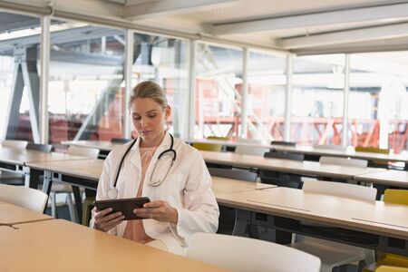 Front view of beautiful Caucasian female doctor using digital tablet in the medical seminar