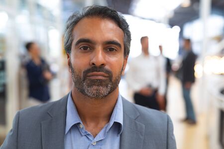 Close-up of caucasian businessman looking at camera in a modern office. International diverse...