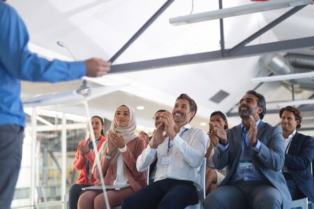 Front view of diverse Business people applauding male speaker in business seminar at conference meeting. International diverse corporate business partnership conceptの写真素材